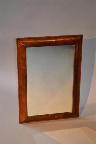 An early 18th century walnut cushion frame mirror