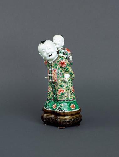 Chinese famille verte biscuit porcelain ‘piggyback’ group, Early Kangxi, circa 1680