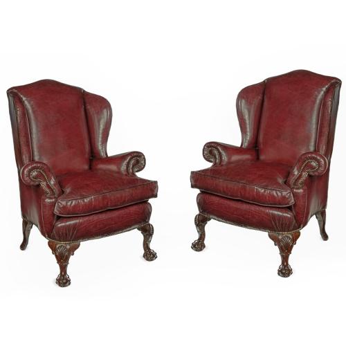 A pair of generous mahogany wing armchairs with shell carved knees