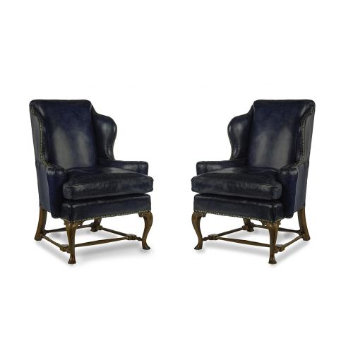 A pair of walnut Georgian style leather wing armchairs